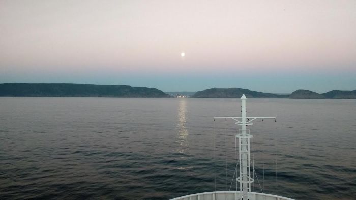 Moonset ahead and sunrise astern entering St Johns